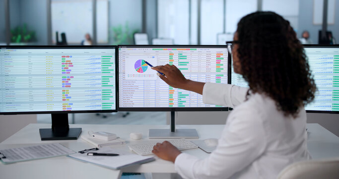 Young African Woman Uses Computer To Manage Medical Billing Codes And Invoices