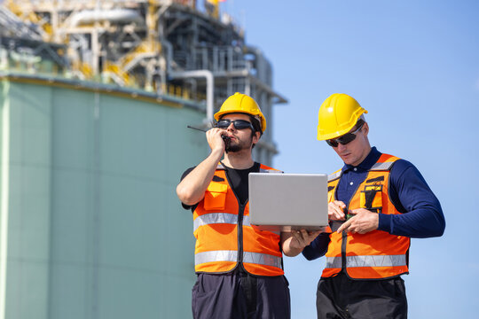 Team of engineer with tablet and walkie talkie at LNG plant, Industrial worker in high visibility gear inspecting natural gas facility, Professional plant operators collaborating with digital devices