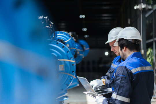 Professional technicians inspect refurbished industrial robot arm systems in warehouse. plant engineering, smart manufacturing, automatic factory, installation, robotics system integration