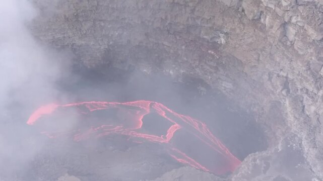 Erta Ale volcano, View of the glowing lava lake inside the crater, with molten rock patterns and dark volcanic rock walls in Zone 2, Afar, Ethiopia.