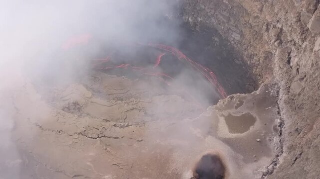Erta Ale volcano, View of the glowing lava lake inside the crater, with molten rock patterns and dark volcanic rock walls in Zone 2, Afar, Ethiopia.
