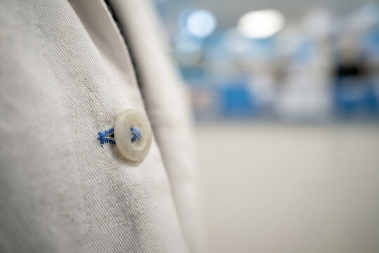 Close up of a white lab coat button
