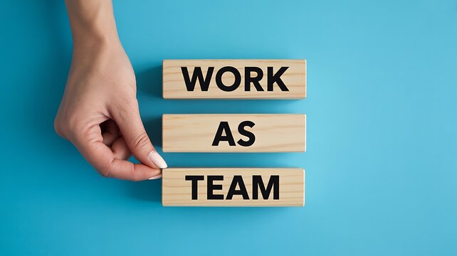 Work as team concept with wooden blocks and pointing hand on blue background