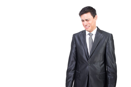 Upset man in elegant suit crying in studio