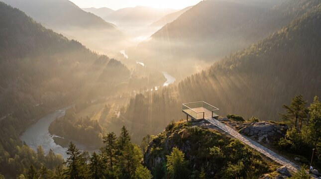 Mountain overlook featuring a stone platform extending above a deep misty valley with a winding river at sunrise mountain overlook