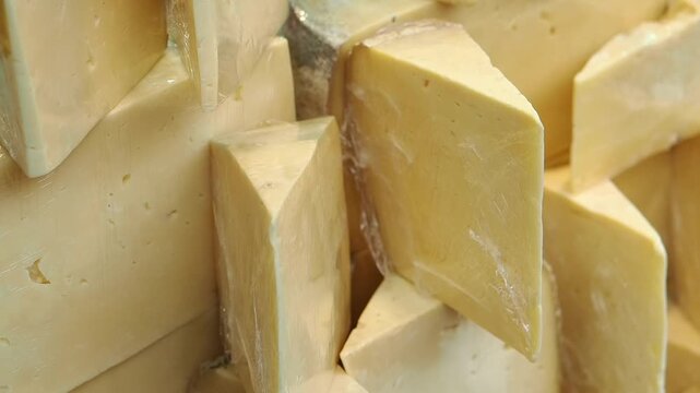 Cheese being cut and arranged in a shop