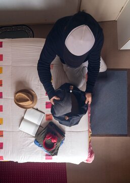 Top down view of a man packing clothes into a bag