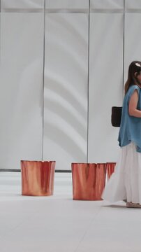 Asian family mother and child with baby carriage in modern shopping mall hall.	