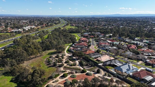 Aerial view looking across Melton in outer western Melbourne, Victoria, Australia.&nbsp;Residential suburban housing developments, green local parkland and a freeway stretching toward distant horizons