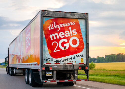 Buffalo, NY - Jun 25, 2026: Highway view of the Wegmans Meals 2GO delivery truck with bright orange HOT‑N‑READY pizza panel, traveling along I‑90 in Buffalo, New York