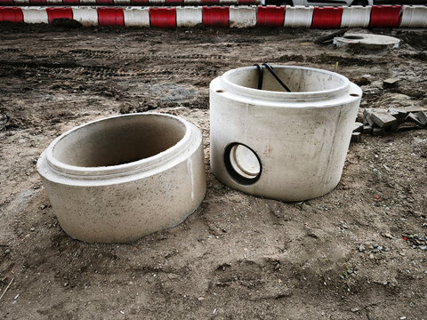 Big construction site. Excavated urban trench with manhole and paved surroundings