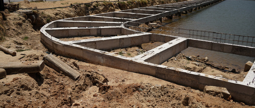 Building process city levee. Exposed foundation rebar grid at site, standing formwork and concrete footings