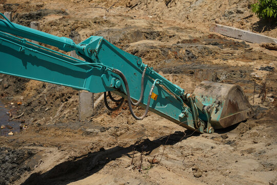Building process city levee. Excavator dredging pond bank