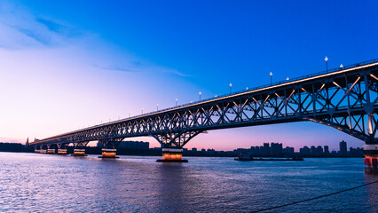 Naklejka premium Suspension Bridge at Dusk suspension bridge dusk artificial light calm modern design