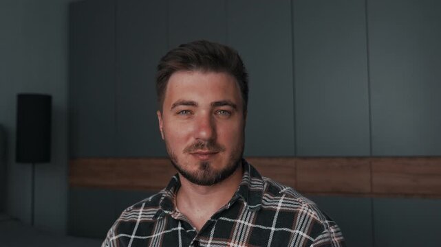 The man shows off, adjusts his eyebrows and stubble, looks into the frame and turns his head.