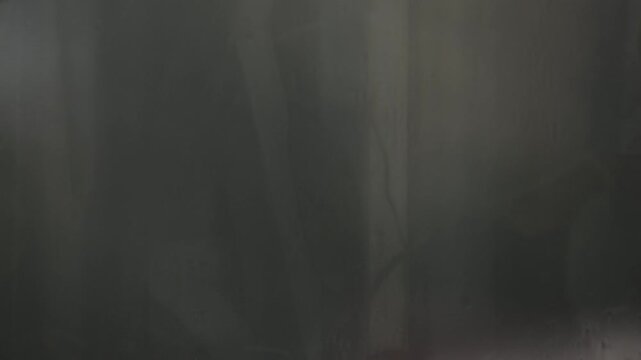 Cinematic rain flowing down a fogged window, illustrating climate change, El Ni&ntilde;o, global warming, extreme weather, heavy rainfall, environmental crisis, and atmospheric instability.