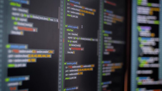 Close up computer monitors displaying fictional programming code and software development interface, technology workspace concept
