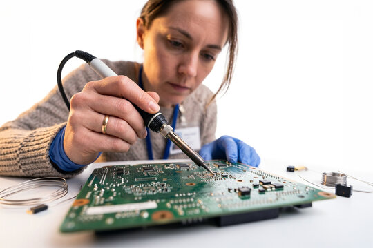 Technician soldering electronic components on a circuit board