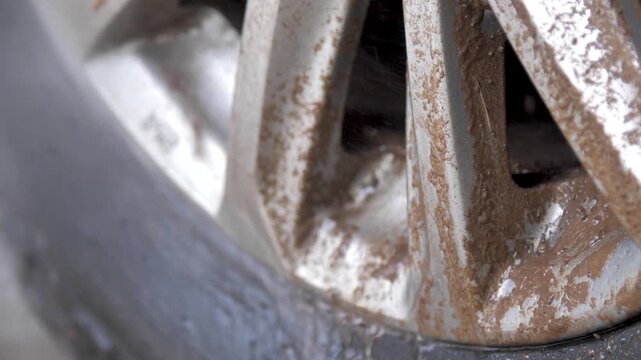Close up footage of a muddy car wheel after off road driving. For off road, vehicle maintenance, adventure, dirt, rugged transportation, and automotive concepts
