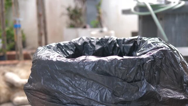 Close up footage of a hand sorting a plastic bottle into a trash bin for proper waste separation. Suitable for recycling, sustainability, environmental protection, and eco-friendly concepts
