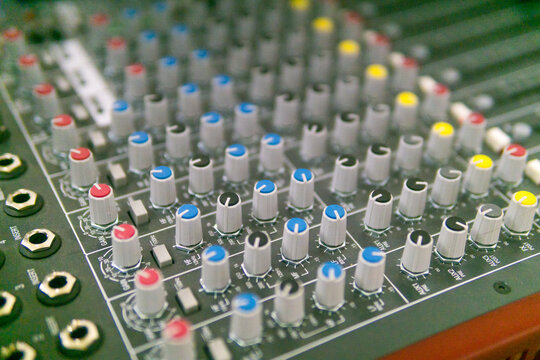 Audio mixing console with buttons and sliders. Selective focus.