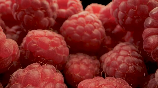 This video features a close-up view of fresh, red raspberries in a bowl. The camera focuses on the intricate details of the raspberries, highlighting their bright color and textured surface.