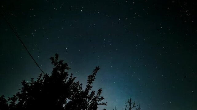 Illuminated clouds drift across a starry night sky in time lapse, atmospheric motion, dramatic cloudscape, celestial nature, mysterious background.