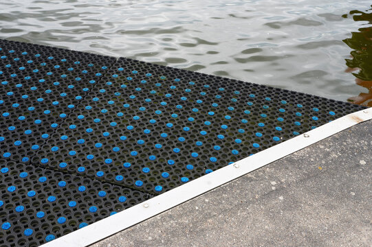 Non-slip plastic dock mat on marina pontoon for safe boarding and slip protection