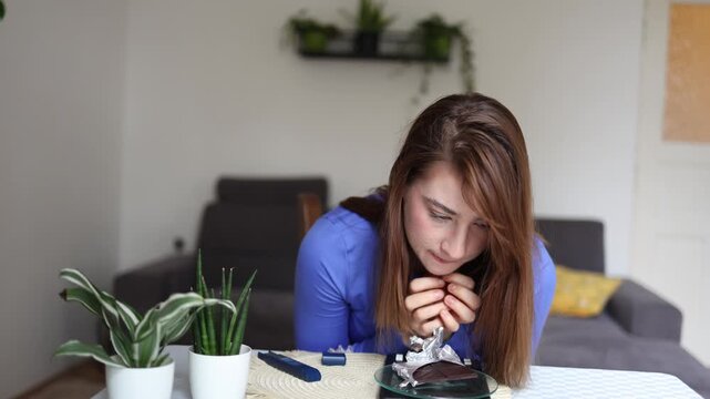 Diabetic woman struggles to resist chocolate as she waits before checking her glucose showing the emotional challenge of balancing cravings with blood sugar control