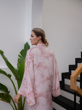 Elegant woman wearing luxury kimono robe in modern tropical home