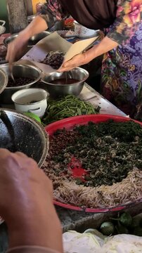 Woman preparing traditional Indonesian Pecel vegetable salad at a street market