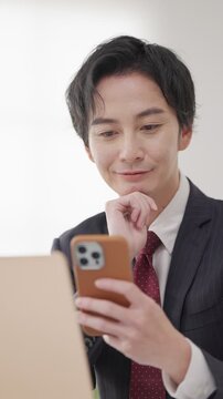 仕事中にスマホを見るビジネスマン男性