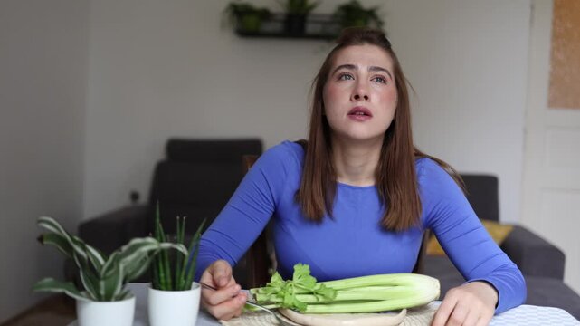 Calorie counting takes over every meal as young woman hesitates before eating celery showing how obsessive food control can replace natural hunger cues daily