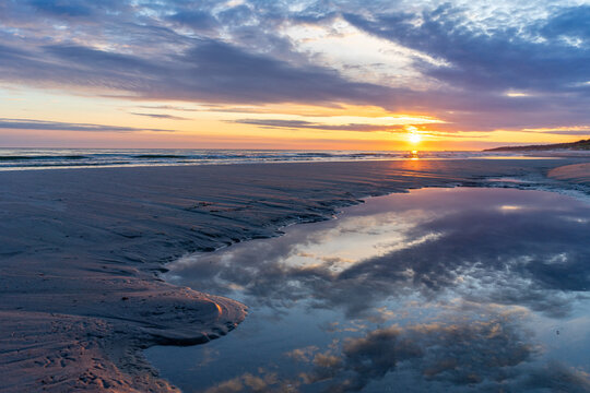 Romantic Sunset Over a Sandy Baltic Sea Beach with Dramatic Clouds &ndash; Vacation and Travel Concept