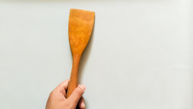han holding a wooden spatula isolated on white