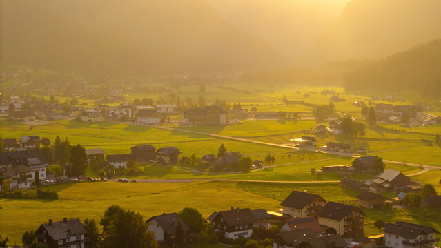 Alpine green fields and traditional wooden houses view of the Gosau village at summer sunny morning.