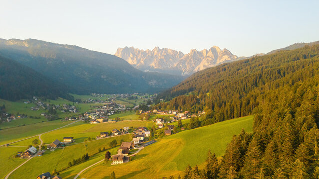 Alpine green fields and traditional wooden houses view of the Gosau village at summer sunny morning.