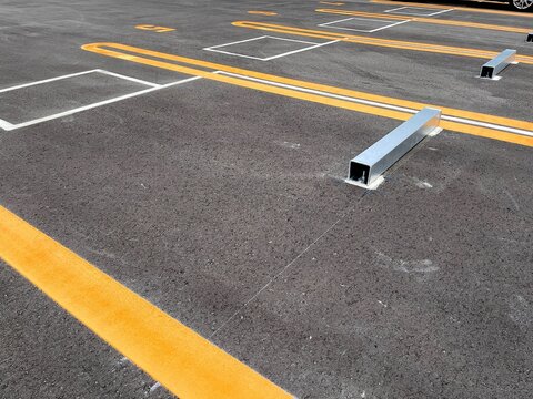 Newly Paved Outdoor Parking Lot with Marked Parking Spaces and Wheel Stops