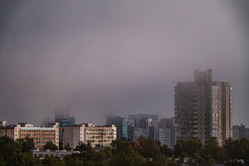 Fototapeta premium Mysterious fog envelops a skyline in the early morning light, transforming the cityscape