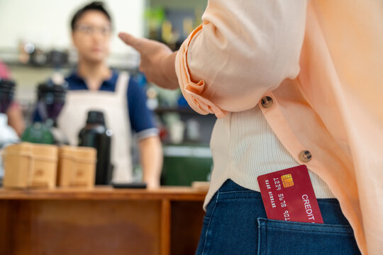 Credit card payment at coffee shop counter. Cafe owner using card reader for cashless transaction while serving coffee drink to customer. Electronic payment technology for small business retail store.