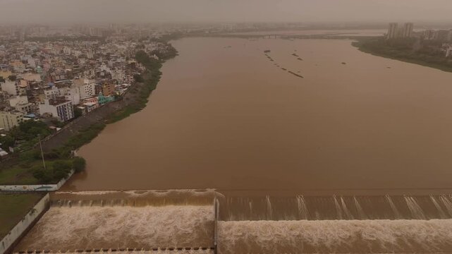 Aerial drone view of the Tapi River and Surat Causeway during monsoon with overflowing river and city skyline in Gujarat India