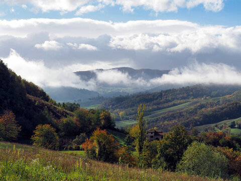 Autumn landscape with fog and rolling hills in Neviano, Italy.
