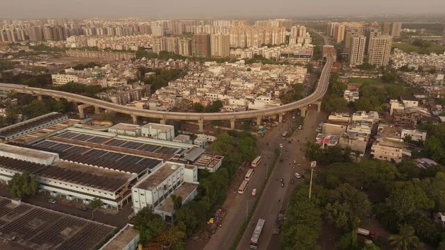 Aerial drone view of Surat Metro Rail elevated viaduct with modern residential skyline and urban infrastructure in Gujarat India