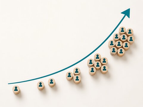 Wooden blocks with human arranged in an upward growing trend line on a white surface representing business growth and success