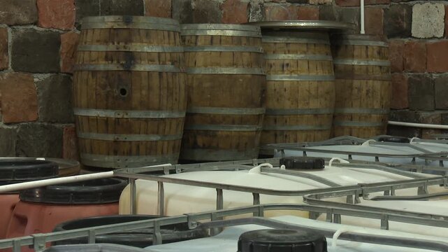 Aged Wooden Barrels Filled with Wine, Brandy or Whiskey in Historic Cellar Warehouse, Dolly Gimbal Movement Along Long Rows of Oak Casks During Alcohol Aging, Fermentation and Storage Process