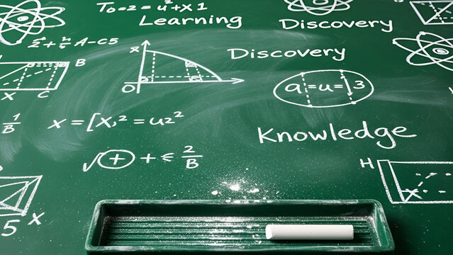 Complex mathematical equations and scientific diagrams written in white chalk on a dark green classroom board