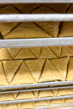 Semi-finished products Crepes filled are stacked in trays ready for baking in a commercial kitchen during a busy food production session