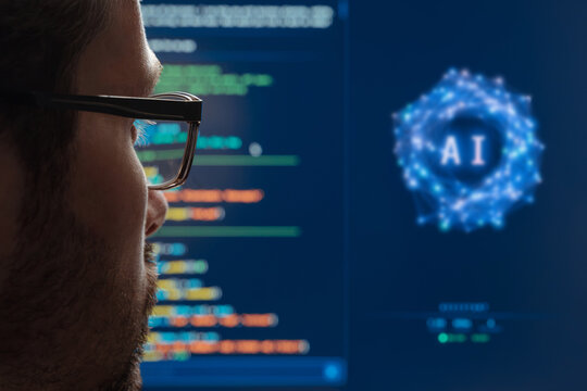 Rear view close up of a programmer watching an AI assistant work on program code on a large monitor. Artificial intelligence chatbots and agent in modern software development. Space for text