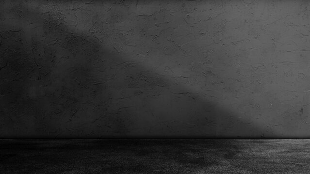 Dark black concrete studio room background with floor and wall illuminated by diagonal light beam ray spotlight shadow effect abstract interior texture for product presentation display mockup.