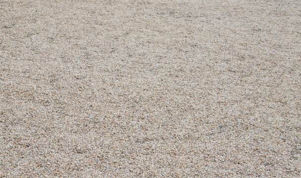 Fine beige gravel ground surface texture background with tiny pebbles